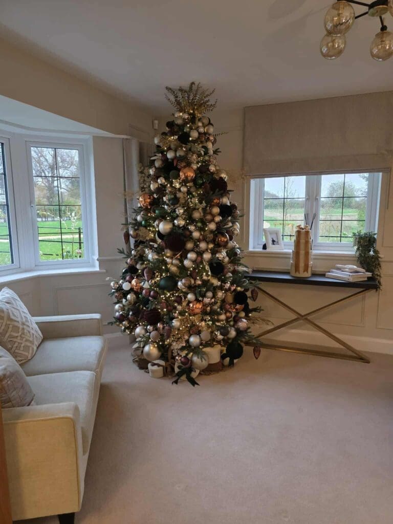 Gold and cream Christmas tree by a bay window, home styling