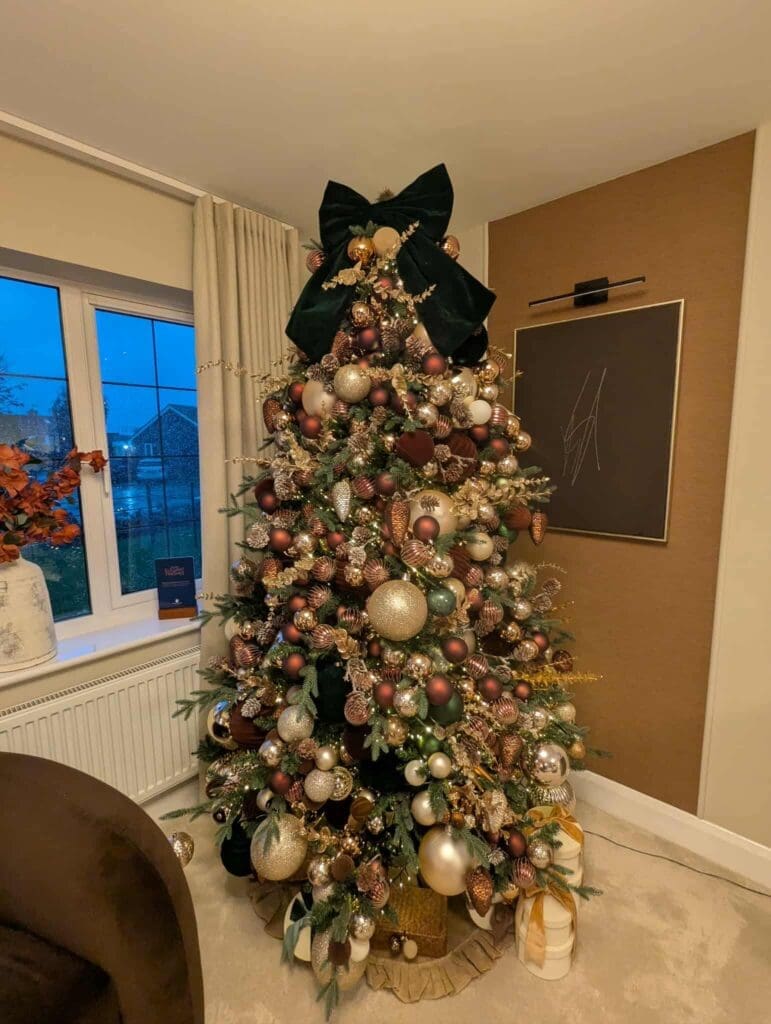 Christmas tree with black bow and gold baubles, home lounge