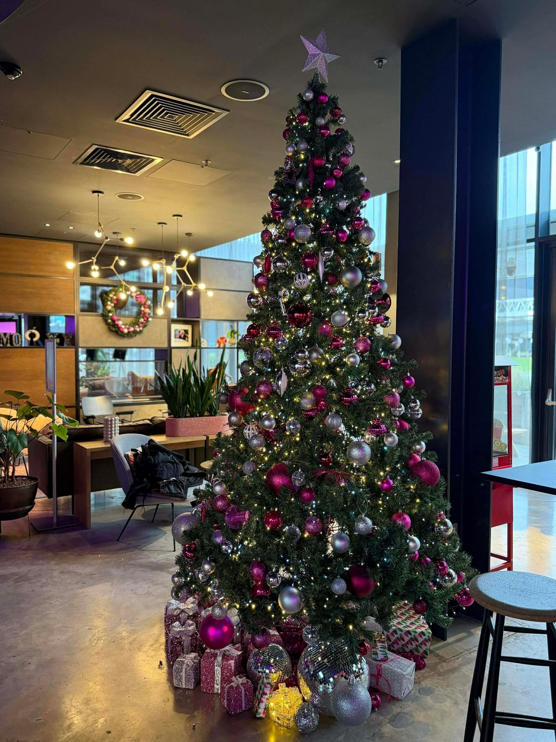 Large pink and silver Christmas tree in a hotel lobby, West Midlands