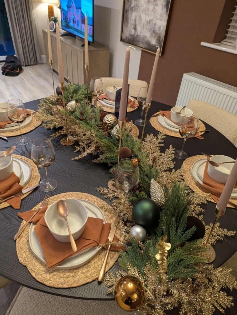 Christmas table setting with pine garland and candles, show home styling