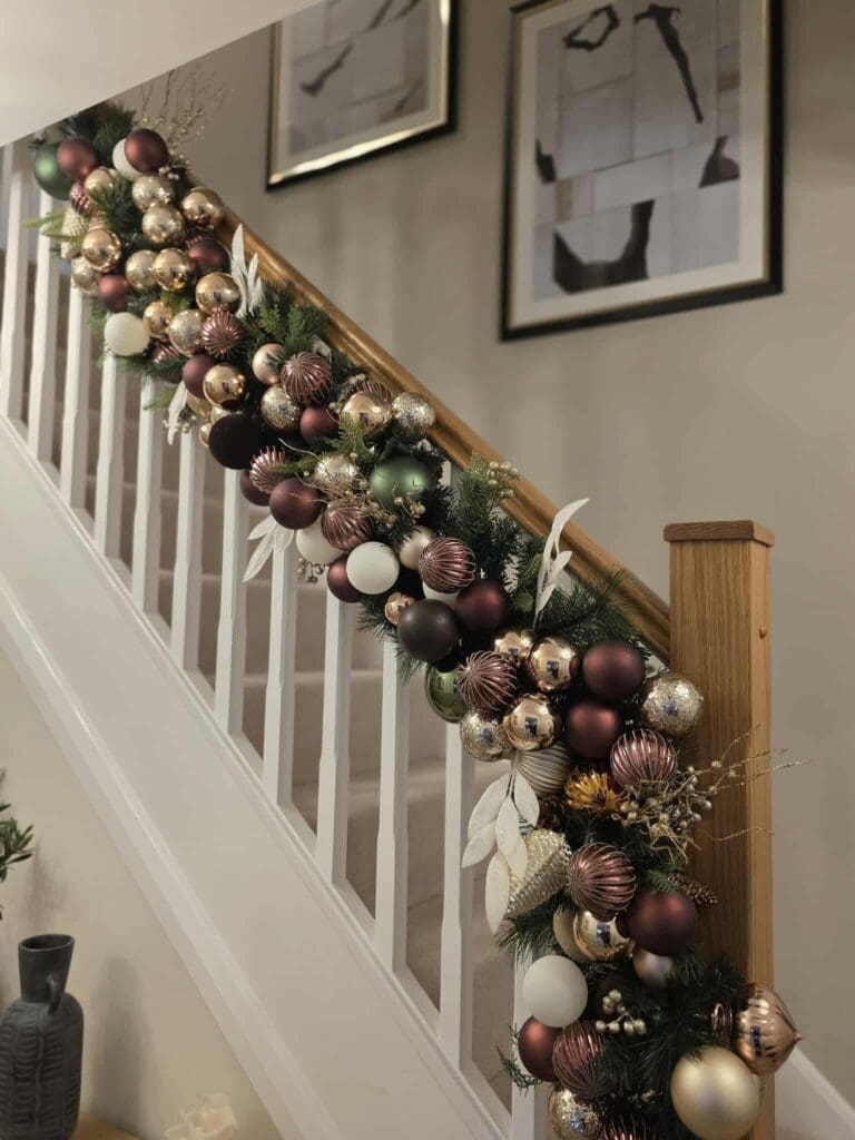 Staircase garland with Christmas baubles on a home handrail, Worcestershire