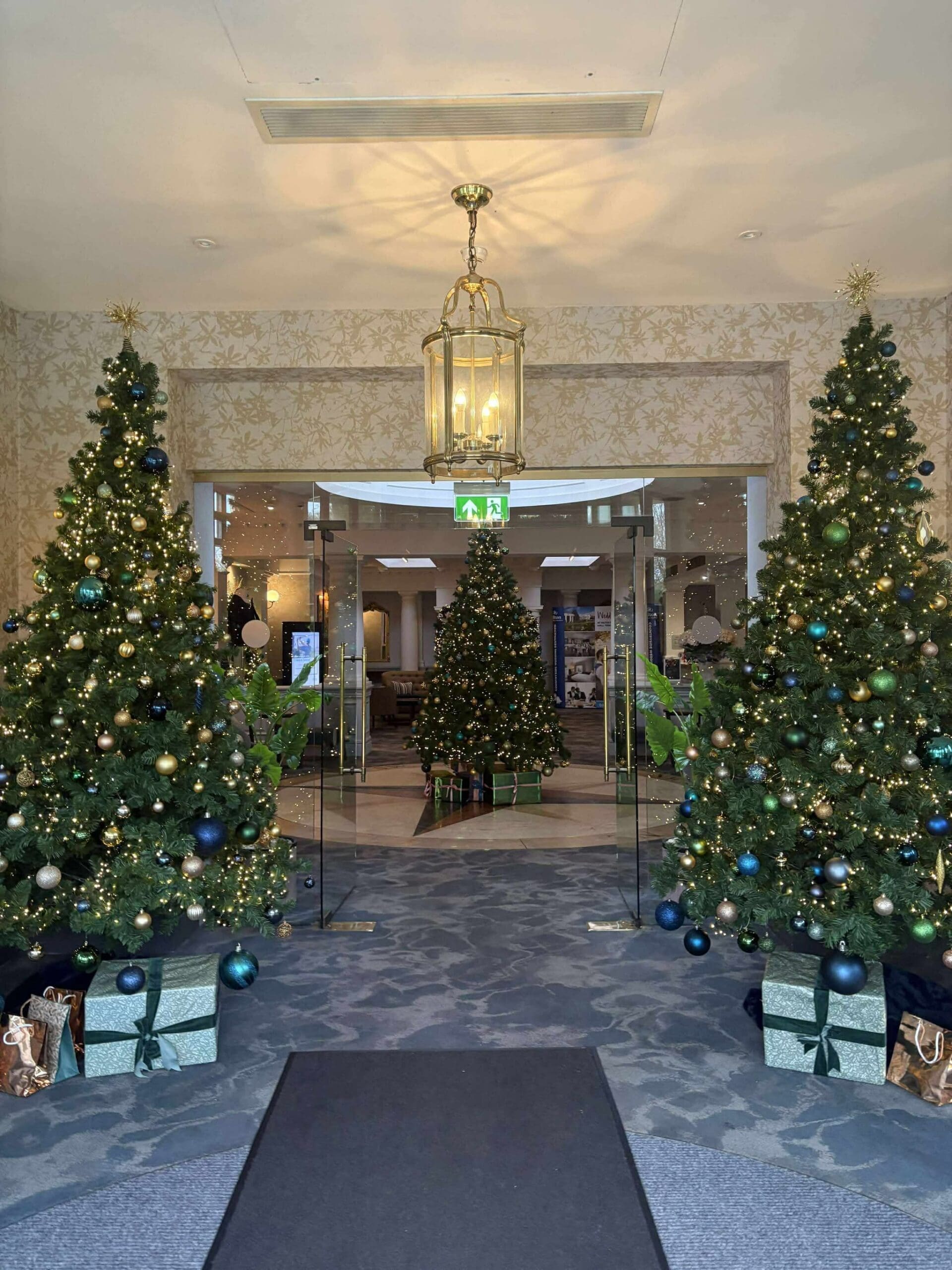 Twin Christmas trees lining a venue entrance walkway, West Midlands
