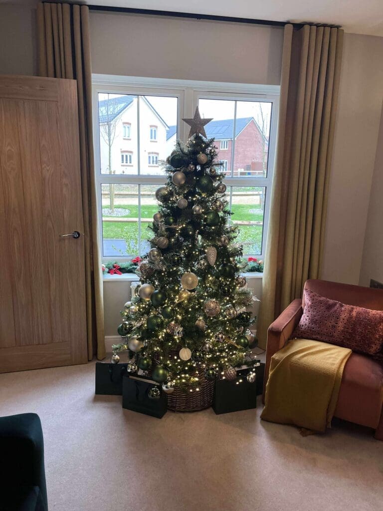Christmas tree with black bow and burgundy baubles, home styling